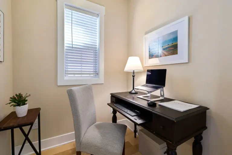 A tidy home office space with a wooden desk, laptop, and ambient lighting. Perfect for remote work. Stock Photo