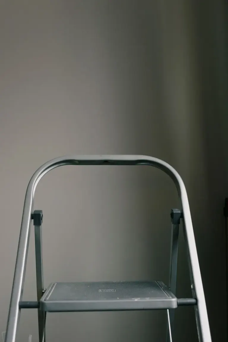 Metal ladder on floor near white wall in room at home during renovation Stock Photo