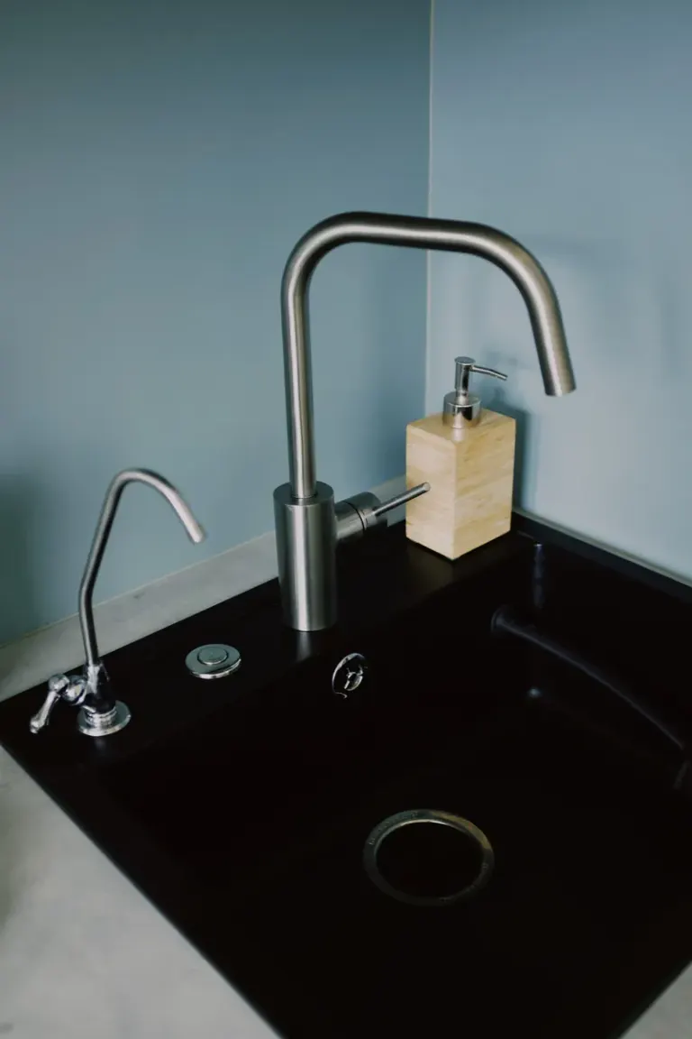 A sleek, modern kitchen sink with a stainless steel faucet and soap dispenser, perfect for contemporary interiors. Stock Photo
