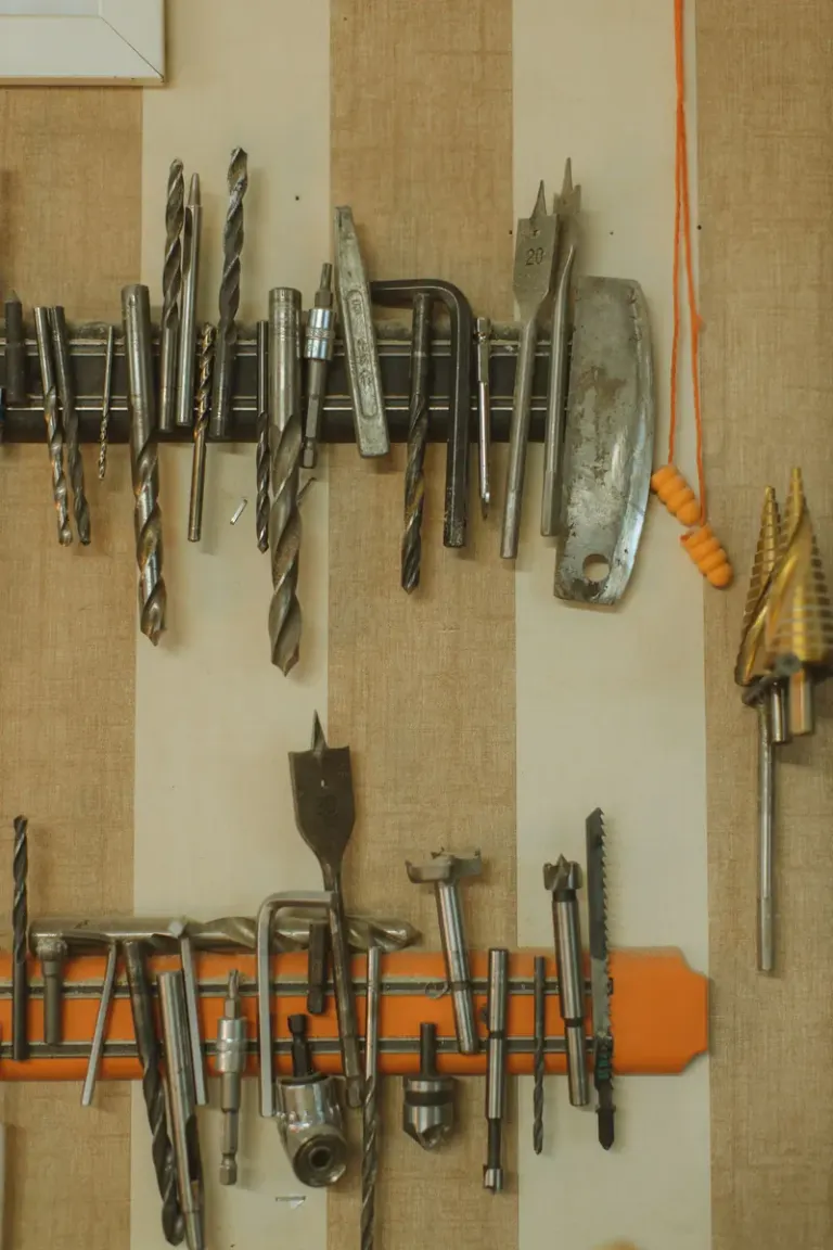 A neatly arranged display of various steel tools on a wall with magnetic strips. Stock Photo