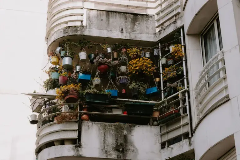 Low angle view of a balcony brimming with vibrant potted plants on a building exterior. Stock Photo
