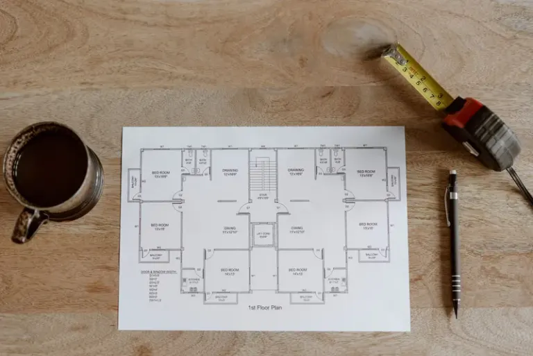 Top view of set of plan of room with tape measure and pen for work for architect with cup with coffee on wooden table in soft daylight Stock Photo