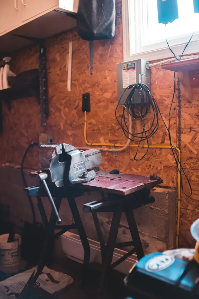 Interior of messy working shop with machine on wooden workbench in daylight Stock Photo