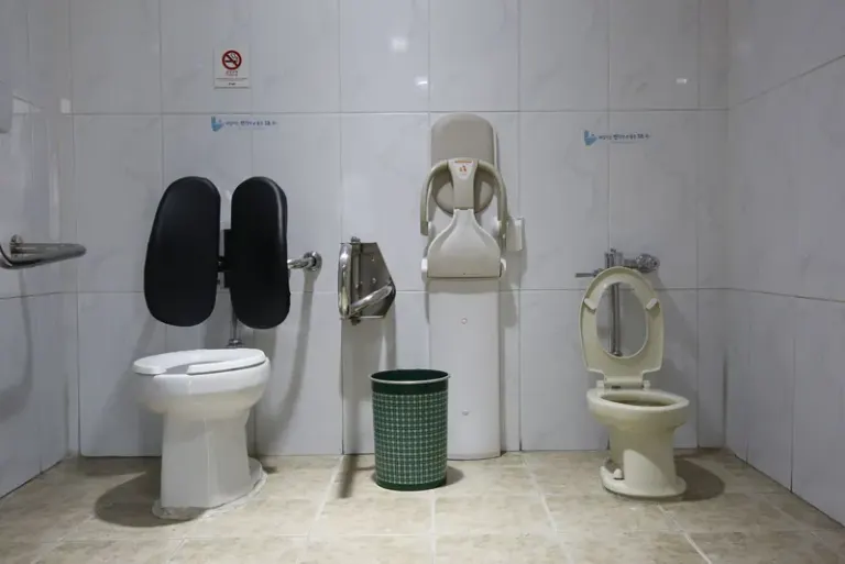 Image of a public restroom with accessible toilet facilities and a baby changing station. Stock Photo
