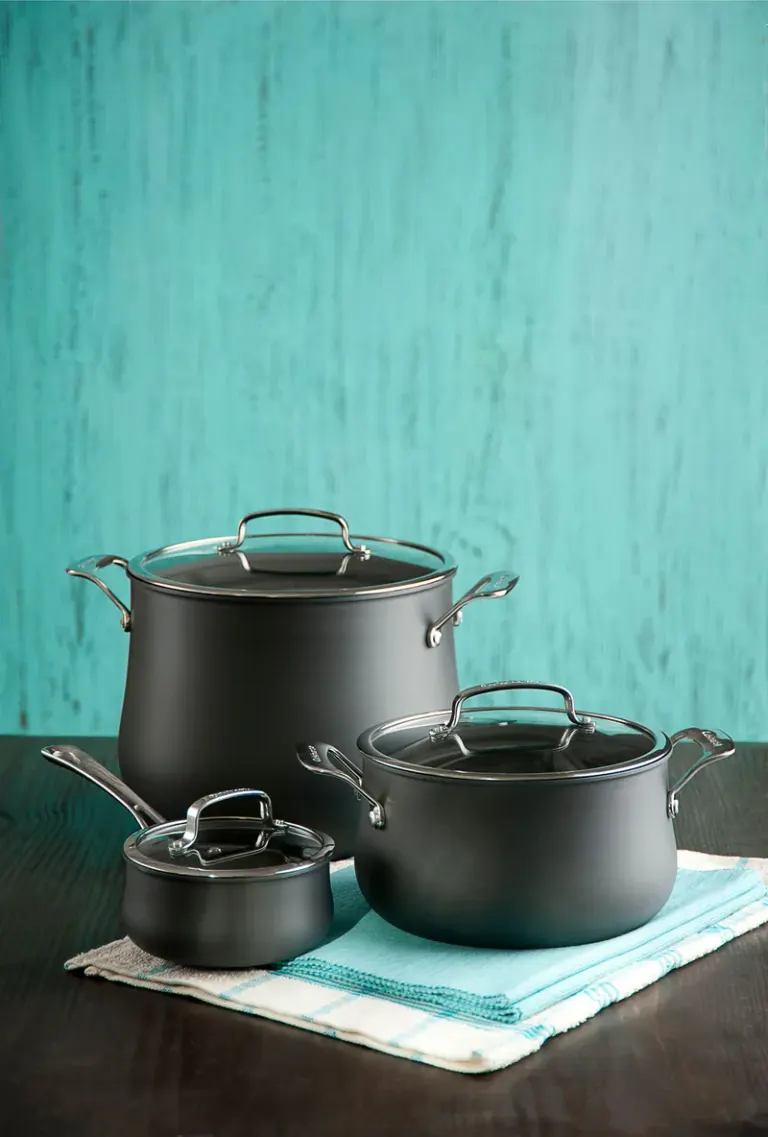 Stylish black pots and saucepan on a turquoise backdrop, perfect for kitchen decor. Stock Photo