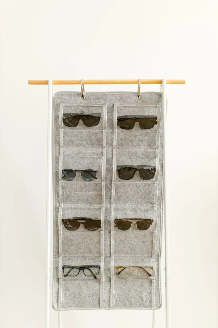 Close-up of a hanging organizer displaying various sunglasses and spectacles. Stock Photo