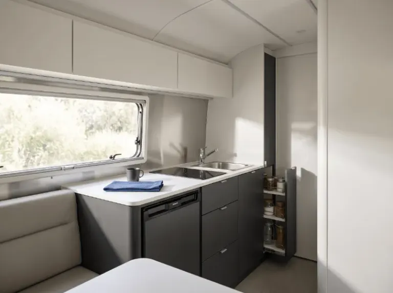 An organized compact kitchen with streamlined cabinetry and pantry storage